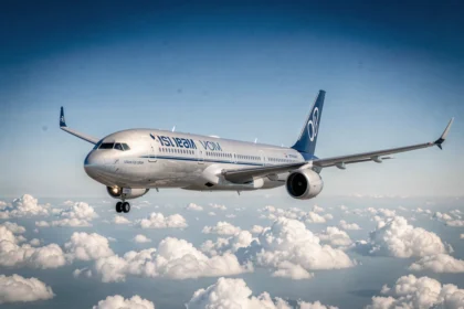 Avion de ligne moderne en vol au-dessus des nuages, vu en contre-plongée sous un ciel bleu profond